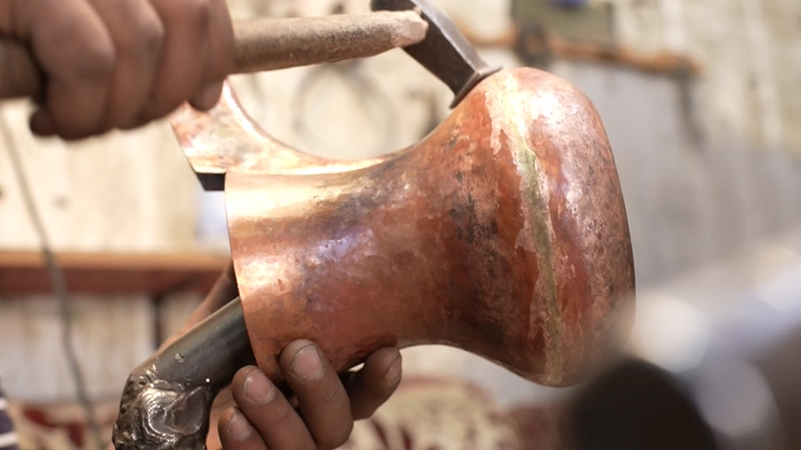 صناعة الدلة النحاسية يدويًا في ورشة، لقطة مقربة.