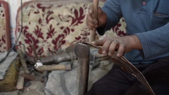 حرفي يصنع دلة تقليدية في ورشة، لقطة مقربة.