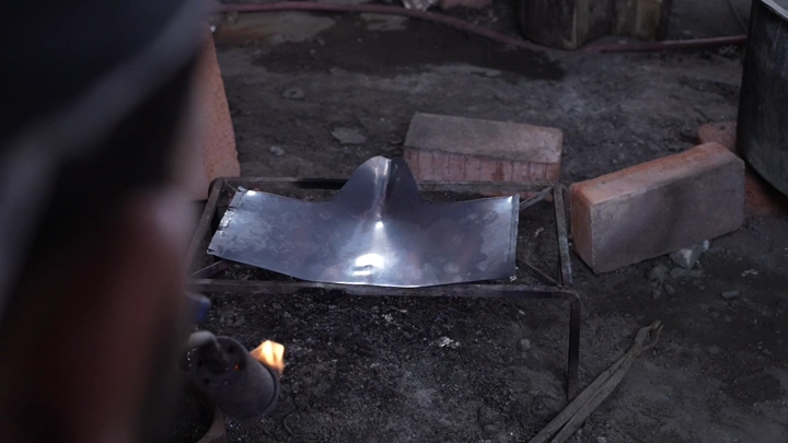 صفيحة معدنية على نار في ورشة حدادة، لقطة قريبة.