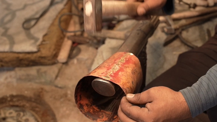 صناعة دلة تقليدية في ورشة حرفية، لقطة قريبة.