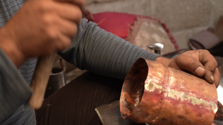 حرفي يصنع دلة نحاسية يدويًا، لقطة مقربة.