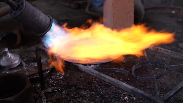 عملية تصنيع الدلة بالنار في ورشة، لقطة مقربة.