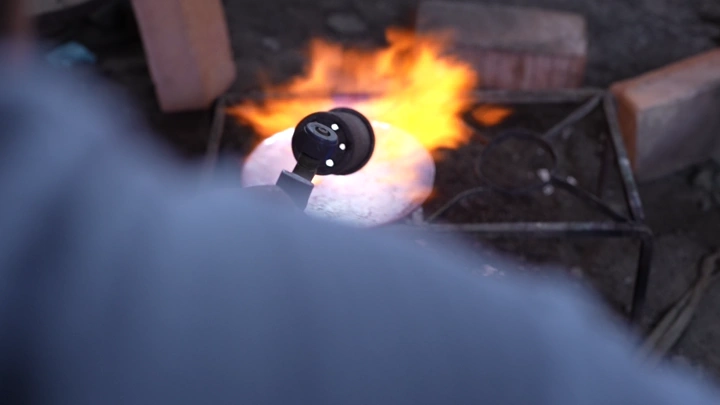 عملية صناعة الدلة بالنار، لقطة مقربة.