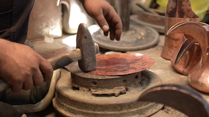 حرفي يصنع دلة نحاسية يدويًا، لقطة مقربة.