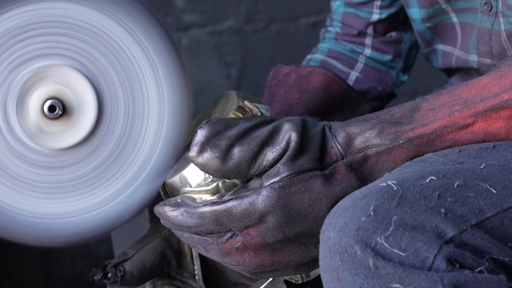 عامل يلمع دلة في ورشة، لقطة مقربة.