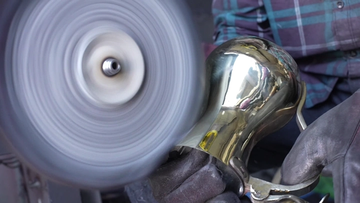 تلميع دلة نحاسية في ورشة، لقطة مقربة.