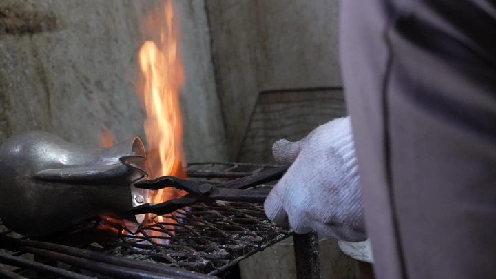 صناعة دلة على النار في ورشة، لقطة قريبة.