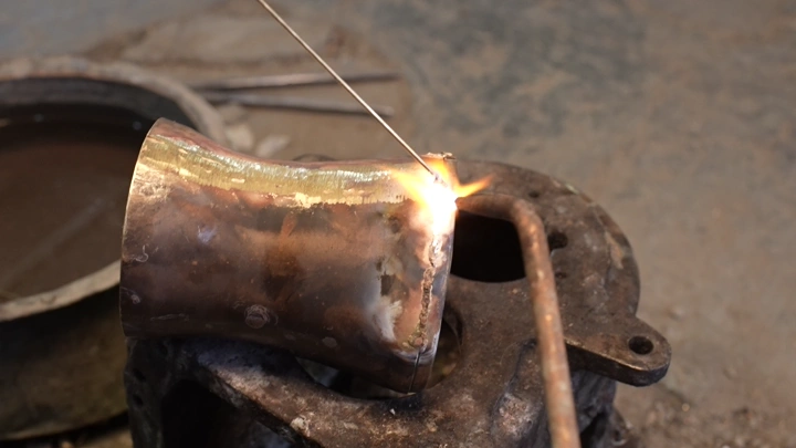 عملية لحام دلة تقليدية في ورشة، لقطة مقربة.