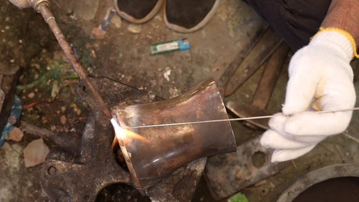 عملية لحام لصناعة الدلة في ورشة تقليدية، لقطة مقربة.