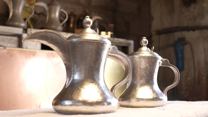 دلتان فضيتان في ورشة تقليدية، لقطة قريبة.