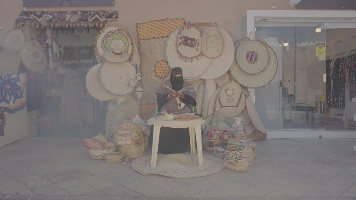 حرفية تعمل في صناعة الخوص، في سوق تقليدي، لقطة متحركة.