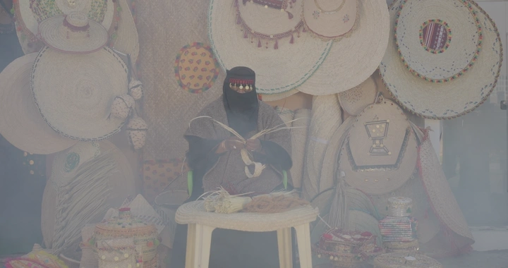 امرأة تصنع منتجات الخوص في سوق تقليدي، لقطة أمامية.