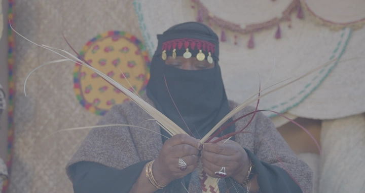 امرأة تصنع منتجات الخوص يدويًا، لقطة مقربة.