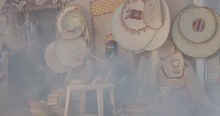 حرفي يعمل في صناعة الخوص في سوق تقليدي، لقطة ضبابية.