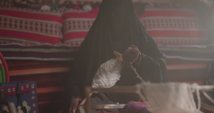 امرأة تنسج السدو في خيمة تقليدية، لقطة قريبة.