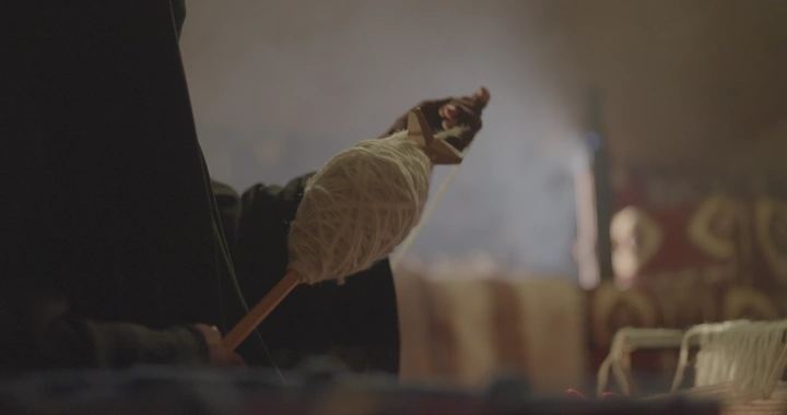 امرأة تنسج السدو في غرفة تقليدية، لقطة قريبة.