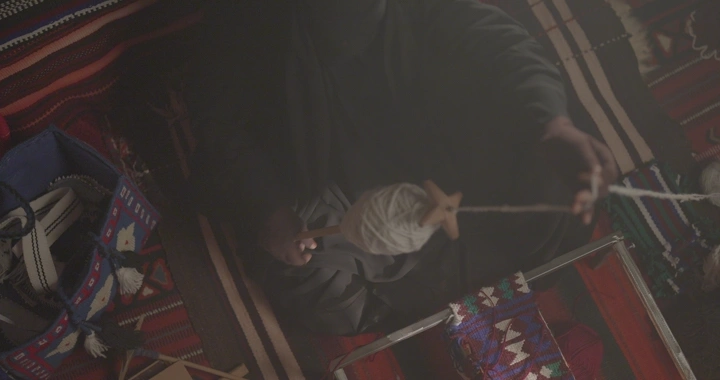 حياكة السدو التقليدية في خيمة، لقطة علوية.