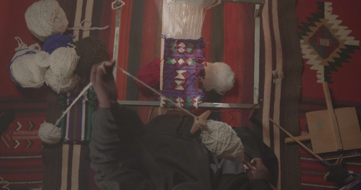 حياكة السدو التقليدية على نول في الداخل، لقطة علوية.