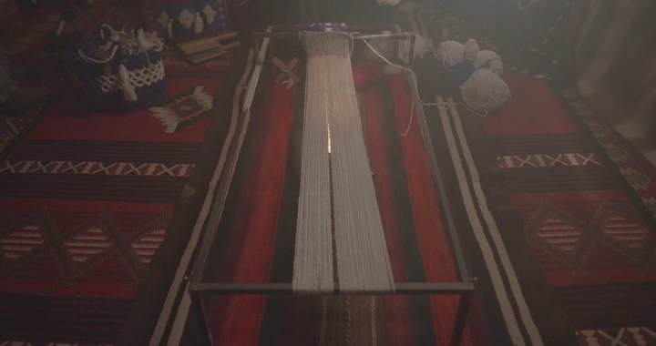 أداة نول سدو تقليدية على سجادة مزخرفة، لقطة علوية.