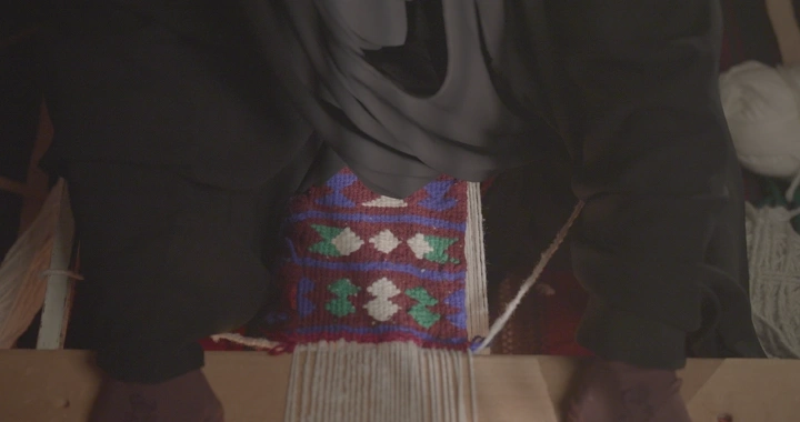 امرأة تنسج على نول سدو تقليدي، لقطة مقربة.