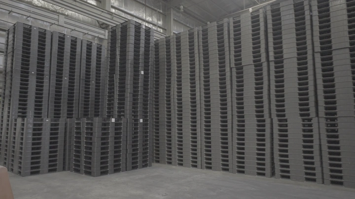 أكوام من الصناديق البلاستيكية في مصنع، لقطة داخلية.