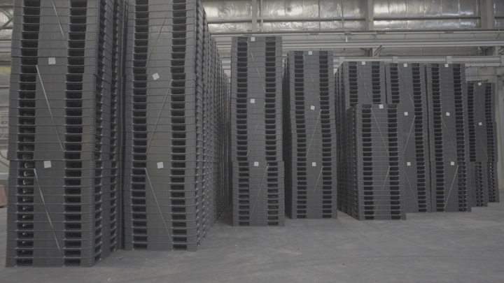 أكوام من الصناديق البلاستيكية في مصنع، لقطة داخلية.