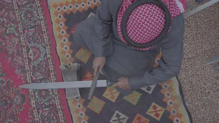 رجل يصنع سيفًا على سجادة ملونة، لقطة علوية.