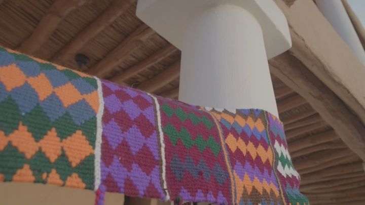 نسيج سدو ملون معروض على عمود خشبي، لقطة قريبة.