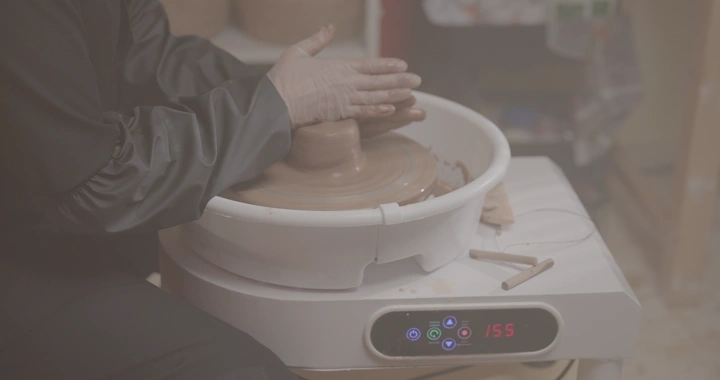 صناعة الفخار على عجلة دوارة في ورشة عمل، لقطة قريبة.