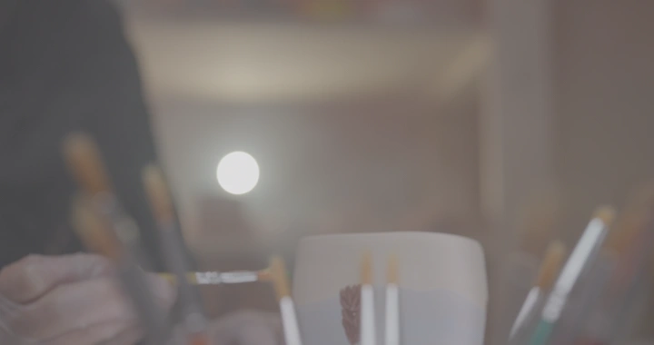 فنجان فخار يُلون في ورشة عمل، لقطة قريبة.