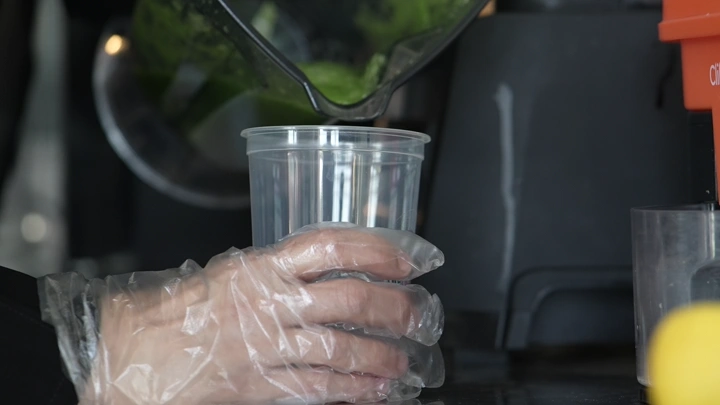 تحضير مشروب ماتشا في كوب بلاستيكي، لقطة مقربة.