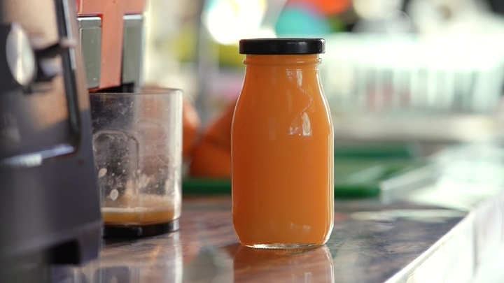 زجاجة عصير برتقال على طاولة مطبخ، لقطة قريبة.