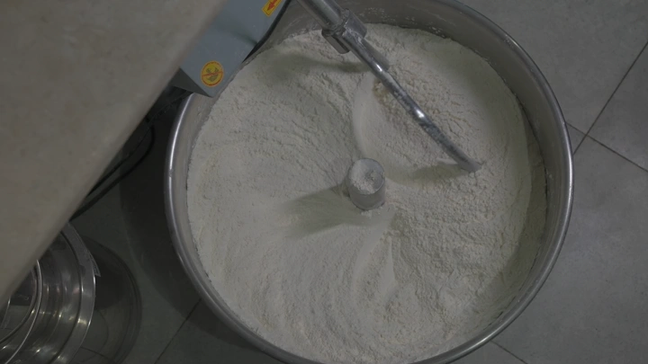 طحين في وعاء معدني كبير، لقطة من الأعلى.