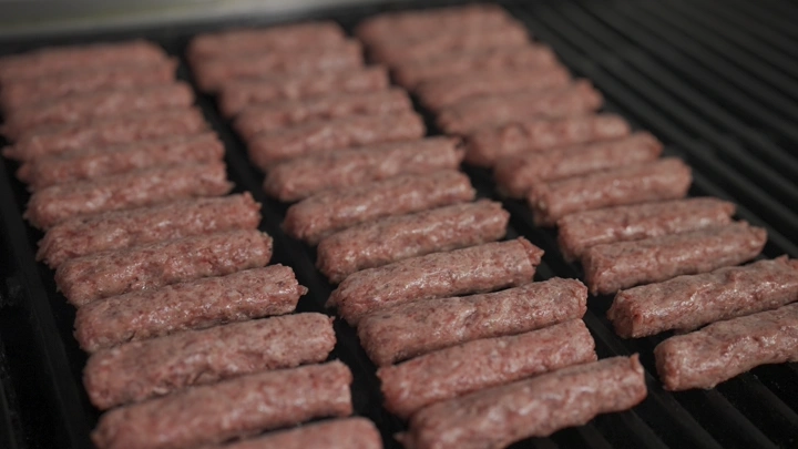 قطع كباب على الشواية في مطبخ، لقطة قريبة.