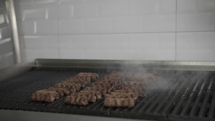 كباب يُشوى على شواية في مطبخ، لقطة قريبة.