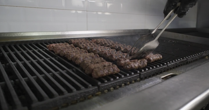 كباب يُشوى على شواية في مطبخ، لقطة قريبة.