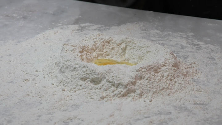 طحين وبيض على سطح مطبخ، لقطة قريبة.