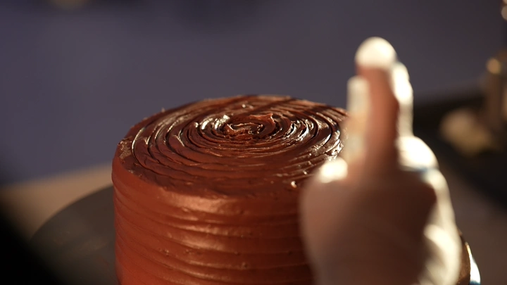 تزيين كيكة شوكولاتة على طاولة، لقطة قريبة.