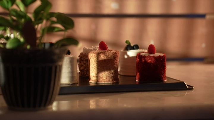 قطع كيك على طاولة بإضاءة دافئة، لقطة قريبة.