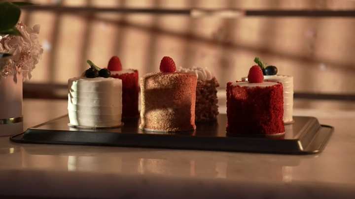 قطع كيك على طاولة مضاءة بإضاءة دافئة، لقطة قريبة.