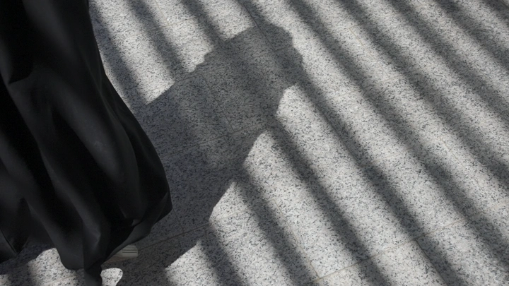 ظل شخص على الأرض تحت ضوء الشمس، لقطة من الأعلى.