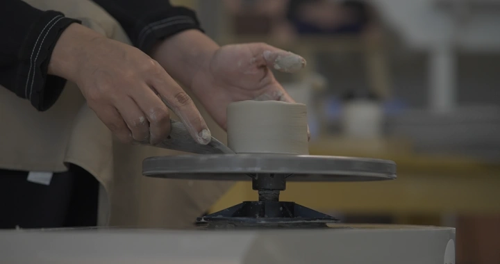 صانع فخار يعمل على عجلة دوارة في ورشة، لقطة مقربة.