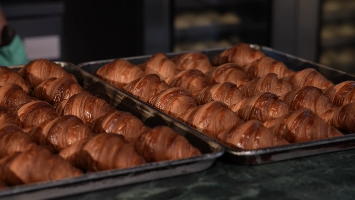 صواني كرواسان طازج في مخبز، لقطة قريبة.