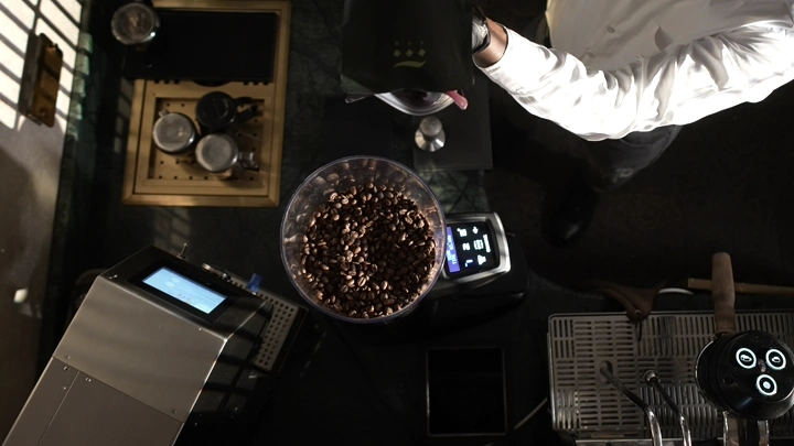 حبات قهوة في مطحنة، لقطة من الأعلى.