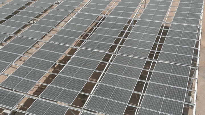 ألواح شمسية مرتبة على سطح مبنى، لقطة علوية.