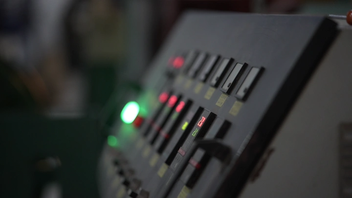 لوحة تحكم مصنع في إضاءة خافتة، لقطة قريبة.