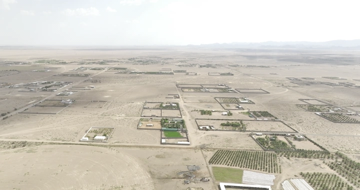 مزارع في الصحراء تحت السماء الملبدة بالغيوم، لقطة جوية.