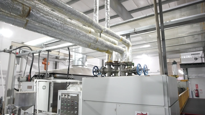 أنابيب ومعدات في مصنع حديث، لقطة داخلية.