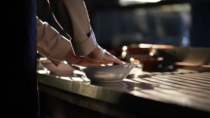 شخص يجهز طبق عصيدة على طاولة مطبخ، لقطة مقربة.