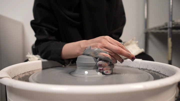 بنت تصنع الفخار في ورشة، لقطة مقربة.